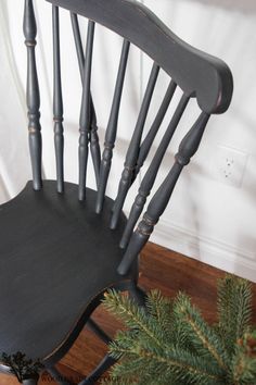 an old fashioned rocking chair sitting on top of a wooden floor next to a christmas tree