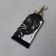 a black and white keychain with a cat on it