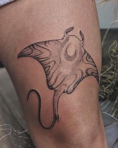 a manta ray tattoo on the thigh