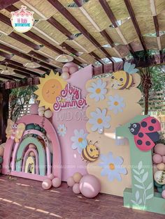 an inflatable sign with flowers and bees on it for a child's birthday party