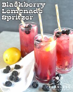 blackberry lemonade spritzer in glasses with strawberries and lemons on the side