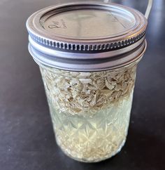 a glass jar filled with oatmeal sitting on top of a table