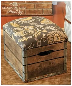 an old wooden box with a floral pattern on it sitting on the floor next to a chair