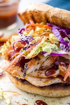 a chicken sandwich with coleslaw and slaw on it