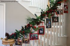 christmas decorations on the banisters and stairs with pictures hanging from them, along with pine cones