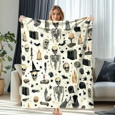 a woman holding up a halloween themed blanket