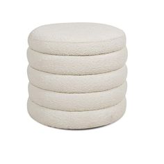 four white round pillows stacked on top of each other in front of a white background