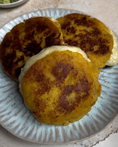 three pancakes on a paper plate sitting on a table