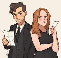 two people dressed in black are standing next to each other and one is holding a piece of paper