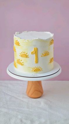 a yellow and white cake with the number one on it