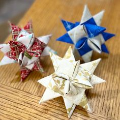 three origami stars sitting on top of a wooden table