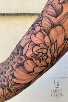 a woman's arm with a flower tattoo on the left side of her arm