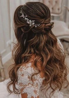 the back of a bride's head with her hair in half - up style