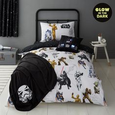 a star wars themed bed with black and white comforter, pillow cases and pillows