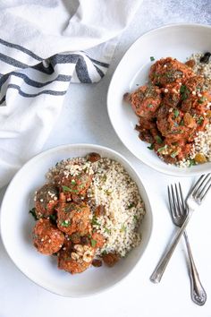 two white bowls filled with meatballs and rice on top of a table next to silverware