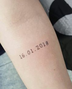 a woman's arm with the date tattooed on it, and her name in black ink