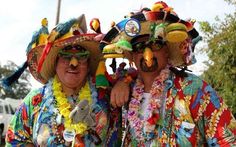 two men dressed in colorful clothing and hats, one with fake birds on his head