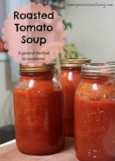 three jars filled with red sauce sitting on top of a table