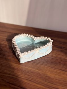 a heart shaped box sitting on top of a wooden table