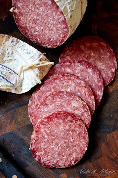 several slices of salami sitting on top of a cutting board