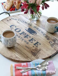 two cups of coffee sit on a wooden tray