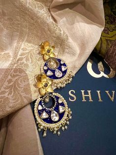 These gorgeous earrings will add a perfect charm to your occasion wear. You will definitely fall in love with this beauty and it will make you stand out among the crowd. Length: 6.5 cms Width: 3.5 cms One of a kind. The uncut Kundan stones embellished on a blue meenakari (enameled) base with pearl drop clusters make it a statement pair. The earrings are the same as shown in the pictures. We have only one piece in this design and color, hence you get what you see in the pictures. Fusion Style Festive Chandbalis For Pierced Ears, Festive Fusion Style Pearl Earrings For Wedding, Festive Fusion Pearl Earrings For Wedding, Festive Fusion Style Wedding Pearl Earrings, Wedding Chandbali Jhumkas With Matching Earrings, Fusion Style Wedding Danglers With Cutdana, Fusion Style Cutdana Danglers For Wedding, Fusion Pearl Earrings With Meenakari For Celebrations, Fusion Style Pearl Earrings With Meenakari For Celebration