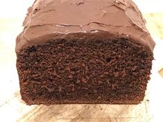 a piece of chocolate cake sitting on top of a wooden cutting board