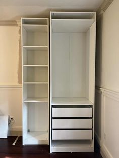 an empty closet with white shelves and drawers