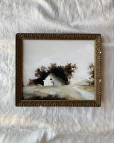 an oil painting of a house in the distance on a white sheet with a gold frame