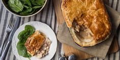 a table topped with a pie next to a bowl of spinach and a plate of food