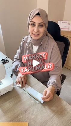 a woman sitting at a desk holding up a sign that reads, mamset najh ya'amul?