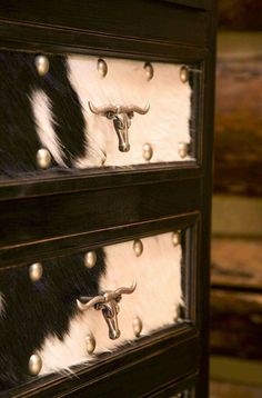 three drawers with cow hides on them and brass rivets at the bottom