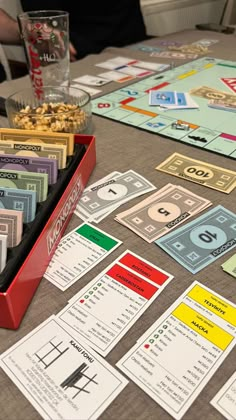 a monopoly board game on a table with money and cards in front of the board