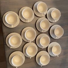 there are many cups and saucers on the table top, ready to be eaten