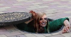 a woman is hiding in a hole on the ground