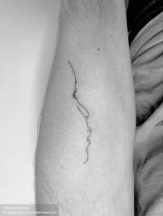 a black and white photo of a person's leg with a tattoo on it