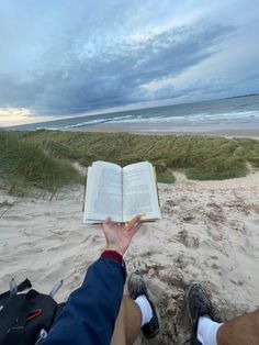 someone is reading a book on the beach