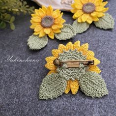 three crocheted sunflowers are sitting on the ground