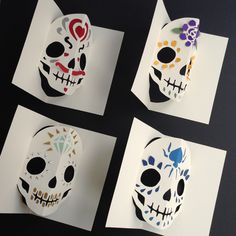 four paper masks with different designs on them