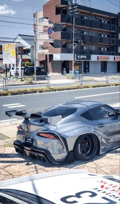 a silver sports car parked on the side of the road