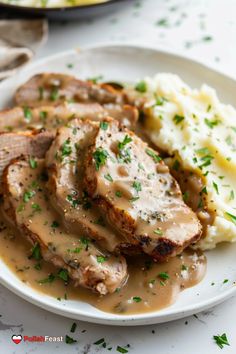 some meat and gravy on a plate with mashed potatoes