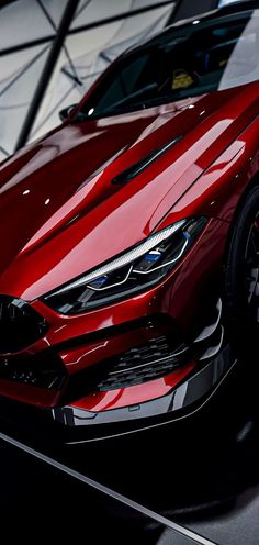 a red sports car is shown in this artistic photo from the front end view, with its hood up