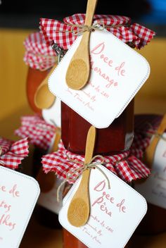 wooden spoons with labels on them sitting next to jars filled with jam