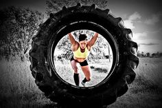 a woman standing in the middle of a large tire