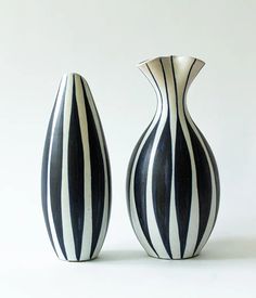 two black and white striped vases sitting side by side