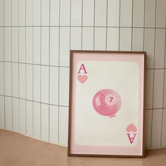 a pink ace playing card in front of a white tiled wall