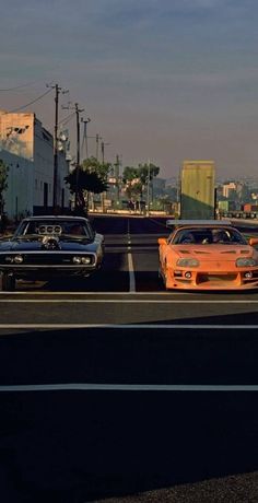 two cars parked next to each other on the side of a road with buildings in the background