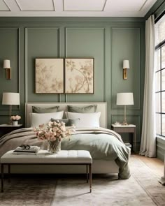 a bedroom with green walls, white bedding and two paintings on the wall above it