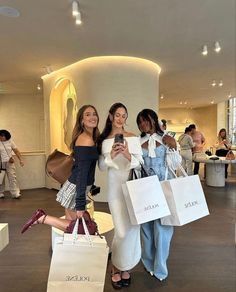 two women standing next to each other holding shopping bags