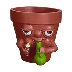 a potted plant with eyes and nose holding a green object in it's mouth